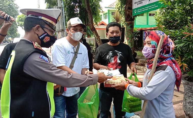 Kasatlantas Polres Probolinggo Kota, AKP Taviv saat memberikan santunan kepada salah satu penyapu jalanan.
