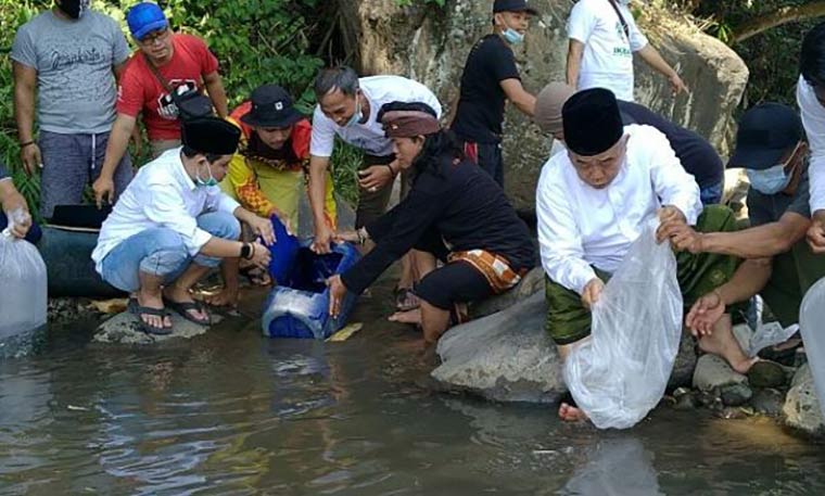 Prof. Dr. KH. Asep Saifuddin Chalim, M.A. dan Muhammad Al-Barra (Gus Bara) saat melepas ikan di sungai Desa Pacet Mojokerto, Sabtu (5/6/2021). foto: mma/ bangsaonline.com