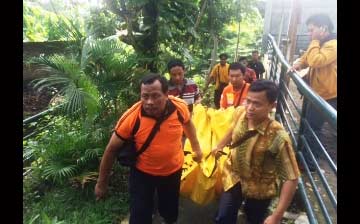 Petugas kepolisian saat mengevakuasi jasad korban dari bawah sungai. (ft: arif kurniawan/ BANGSAONLINE)