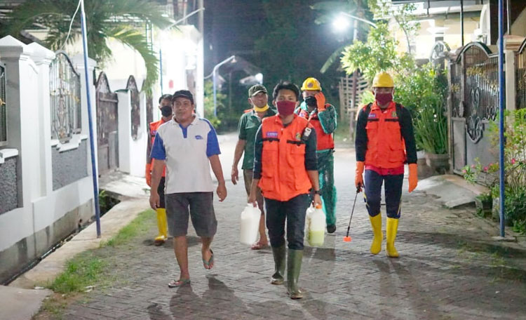 Tim gabungan saat melakukan penyemprotan disinfektan untuk menenangkan warga.