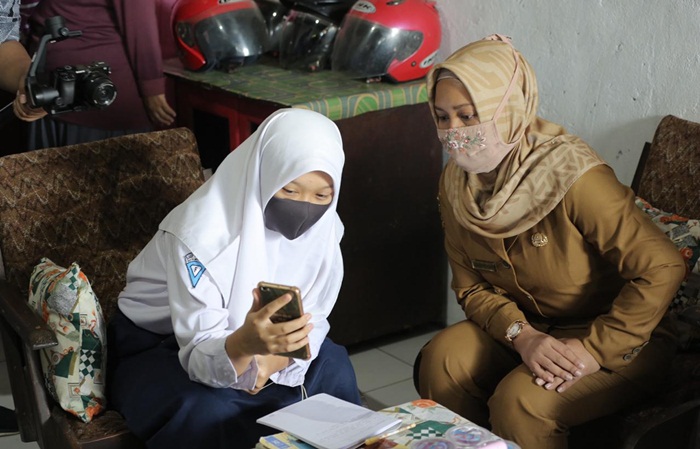 Ning Ita sedang meninjau pembelajaran daring di salah satu rumah siswa.