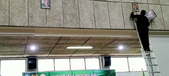 Seorang petugas naik tangga mengganti gambar Wapres Jusuf Kalla dengan gambar Wapres KH Ma