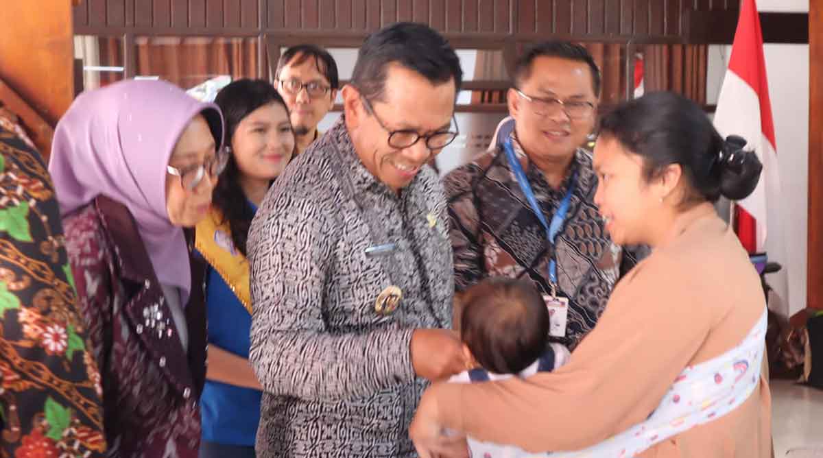 Wali Kota Batu saat menyapa seorang bayi bersama ibunya di Posyandu balita.