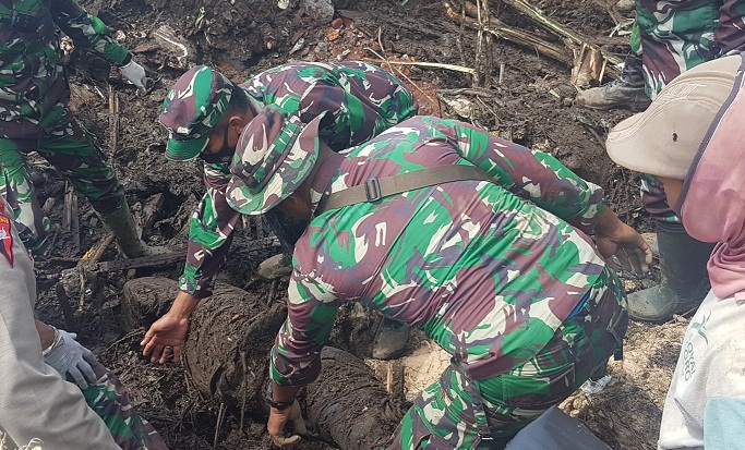 Anggota TNI, bersama beberapa pihak terkait saat berupaya mengevakuasi korban bencana banjir bandang di Kota Batu.