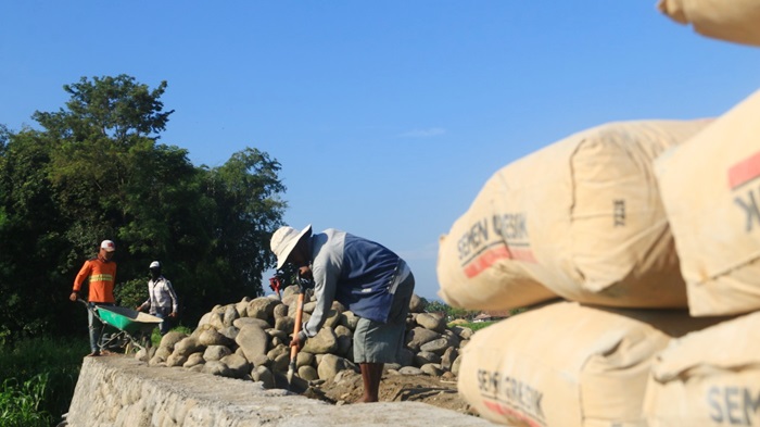 Pembangunan jalan rabat beton dan tembok penahan tanah bantuan CSR SIG di Desa Randujalak, Kecamatan Besuk, Kabupaten Probolinggo, Jawa Timur. foto: ist.