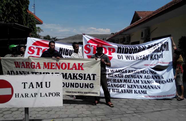 Warga Kedundung membentangkan spanduk tolak Graha Poppy di kantor Satpol PP. foto: yudi eko purnomo/ BANGSAONLINE