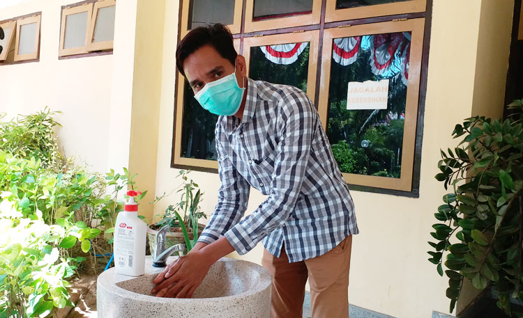 Mohammad Hotib, Ketua Fraksi PKB DPRD Bangkalan saat melakukan cuci tangan sebelum masuk ke kantor, Rabu (15/4).