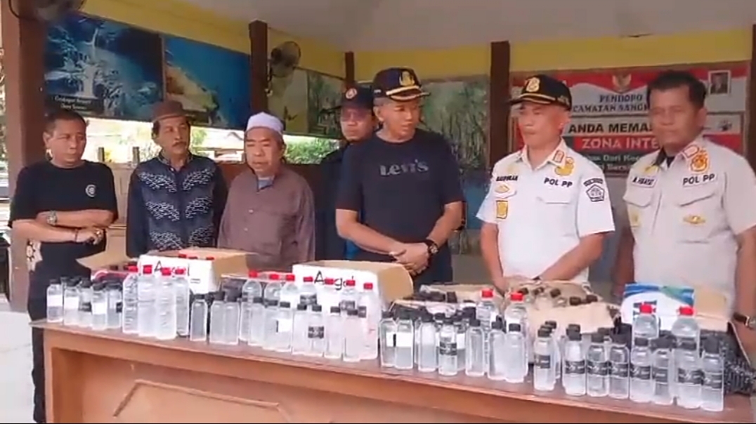 Petugas Satpol PP Gresik bersama tokoh masyarakat saat pemusnahan miras. Foto: Ist.