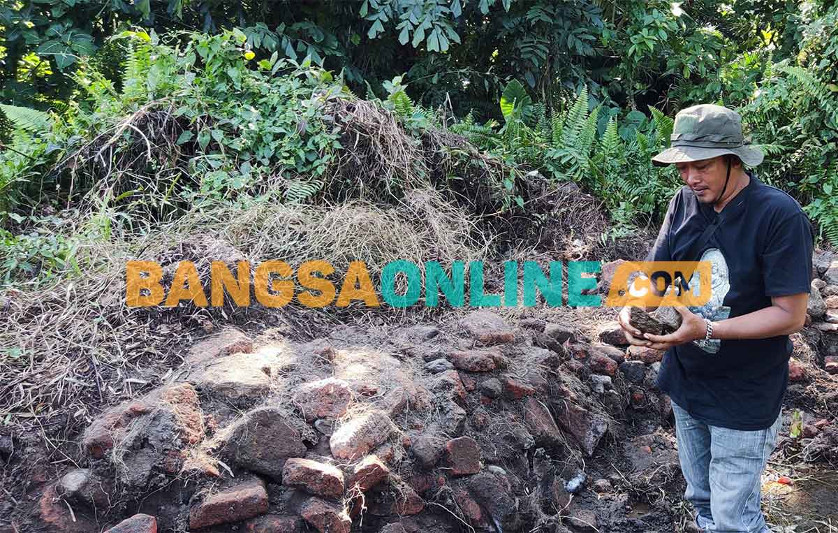 Susilo saat memperlihatkan temuan batu bata dan batu andesit di Sumber Lotes, Desa Jajar, Kecamatan Wates, Kabupaten Kediri. Foto: MUJI HARJITA/BANGSAONLINE