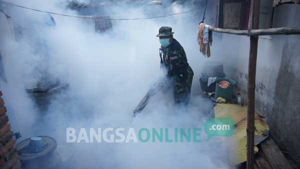 Aksi fogging yang dilakukan oleh pasukan Kodim 0814 di desa Puton. foto: rony suhartomo/ BANGSAONLINE