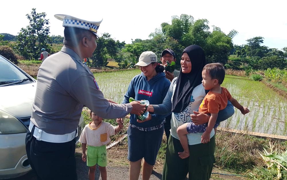 Satlantas Polres Magetan saat bagi-bagi nasi bungkus sambil berpatroli.