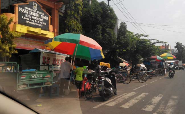 Aksi pedagang bermobil yang memanfaatkan lahan parkir di Pasar Tanjung Anyar untuk jualan. foto: yudi eko purnomo/ BANGSAONLINE