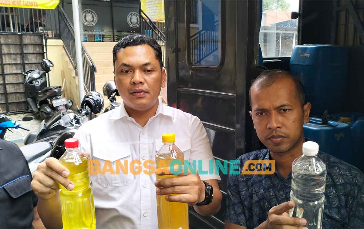 Petugas saat menunjukkan minuman keras yang disita dalam gudang di Jalan Sawunggaling, Kelurahan Sentul, Kecamatan Kepanjen Kidul, Kota Blitar. Foto: AKINA NUR ALANA/BANGSAONLINE