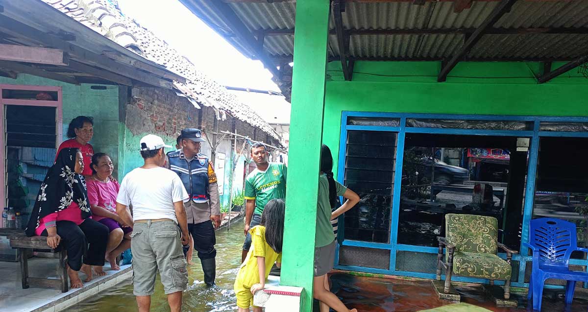 Bhabinkamtibmas Polsek Taman, Aipda Dwi Priyo, menyalurkan bantuan sembako kepada korban banjir di RT 19 RW 03 Dusun Dodokan, Desa Tanjungsari, Sidoarjo.