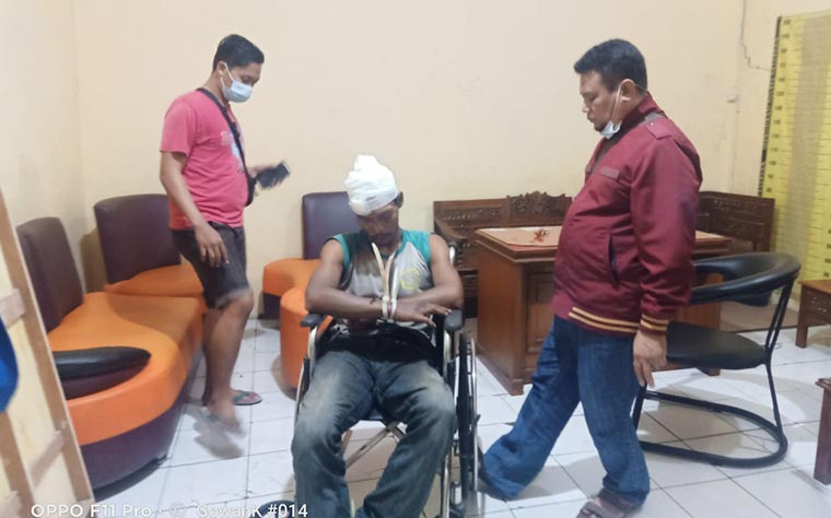 Tersangka duduk di kursi roda saat hendak menjalani pemeriksaan.