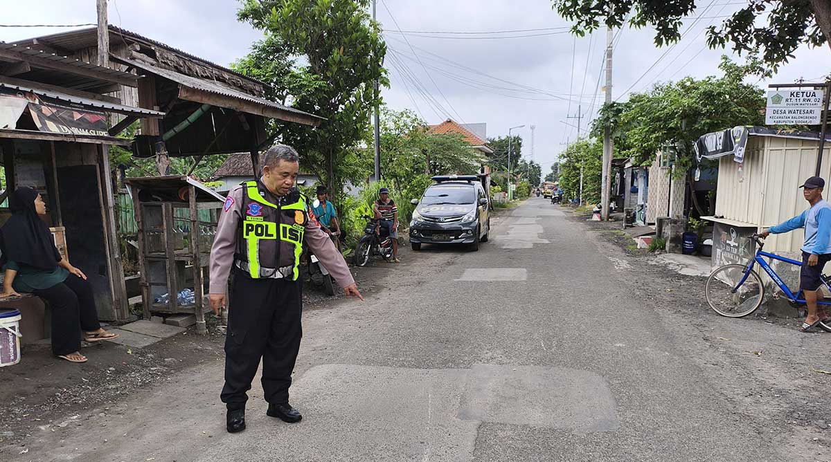 Petugas ketika menunjukkan lokasi kecelakaan yang melibatkan pengendara motor dan pejalan kaki di Desa Watesari, Kecamatan Balongbendo, Sidoarjo.