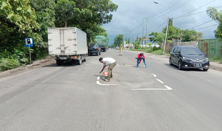 Aksi Forum Bikers Tuban menandai jalan yang rusak menggunakan cat.