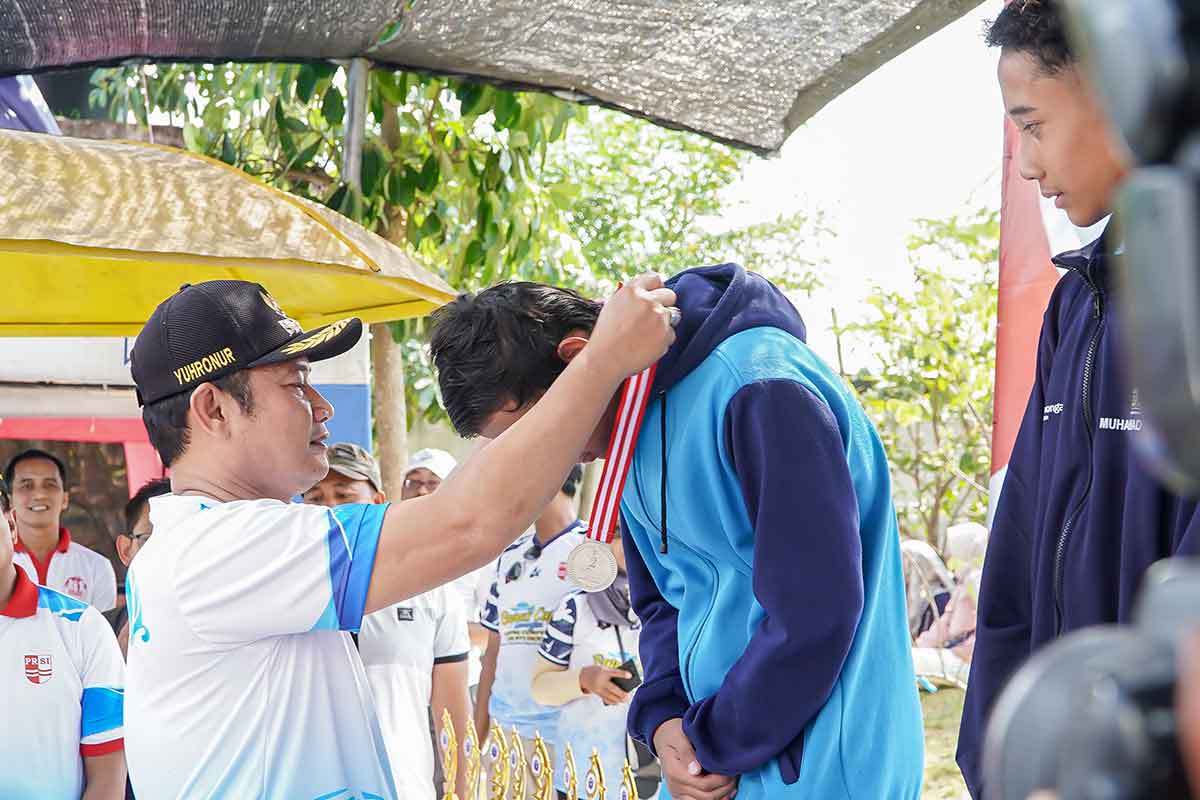 Bupati Lamongan, Yuhronur Efendi saat memberikan medali dalam kompetisi renang.