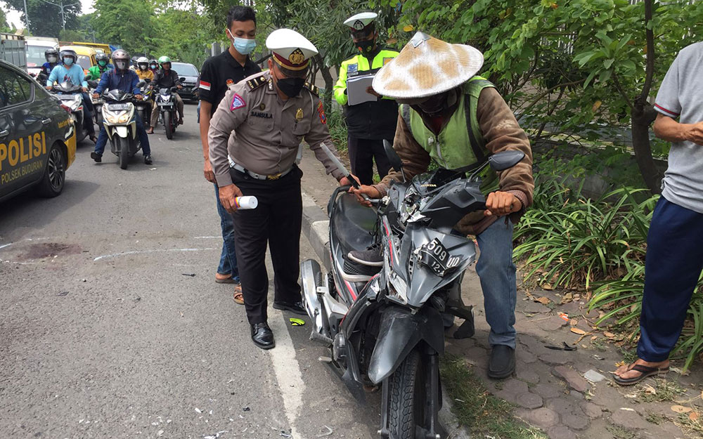 Kondisi motor yang dikendarai korban tampak ringsek usai menabrak median jalan.