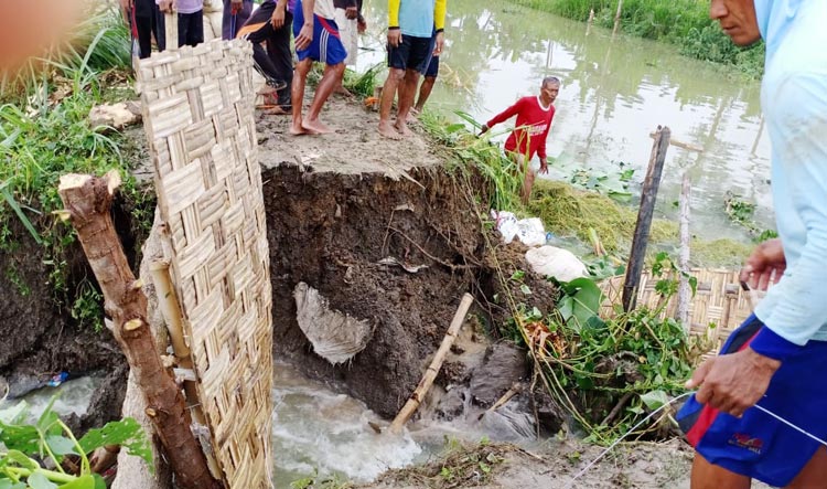 Warga berupaya membendung air menggunakan karung berisi tanah serta bambu.