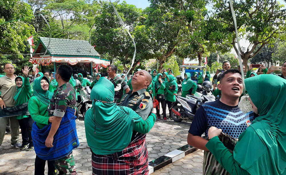 Suasana lomba makan kerupuk berpasangan yang diikuti oleh anggota dan seluruh perwira Kodim 0826/Pamekasan.
