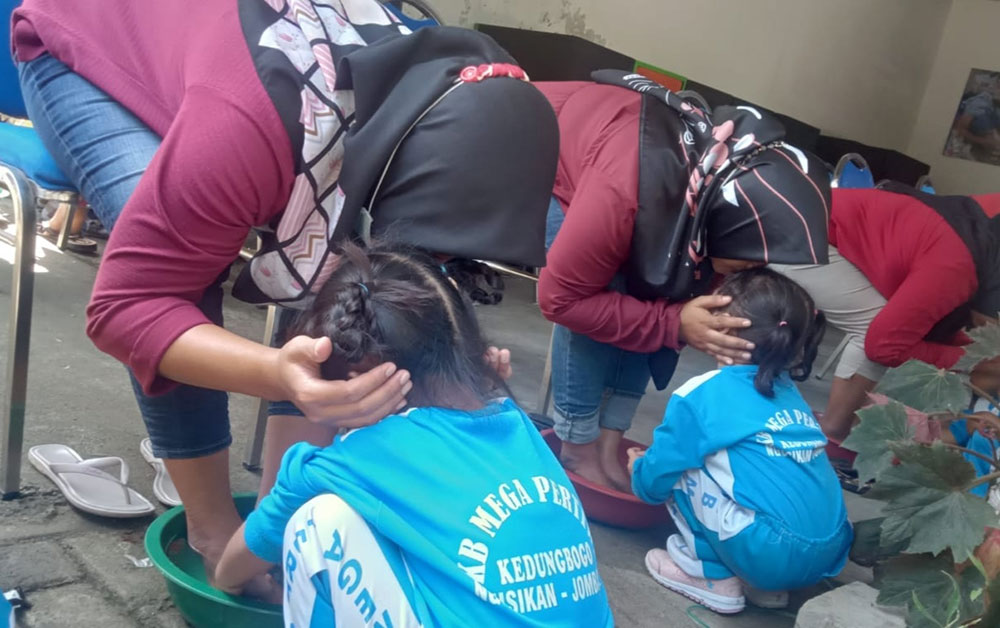 Murid-murid PAUD di Ngusikan saat membasuh kaki ibundanya. foto: AAN AMRULLOH/ BANGSAONLINE