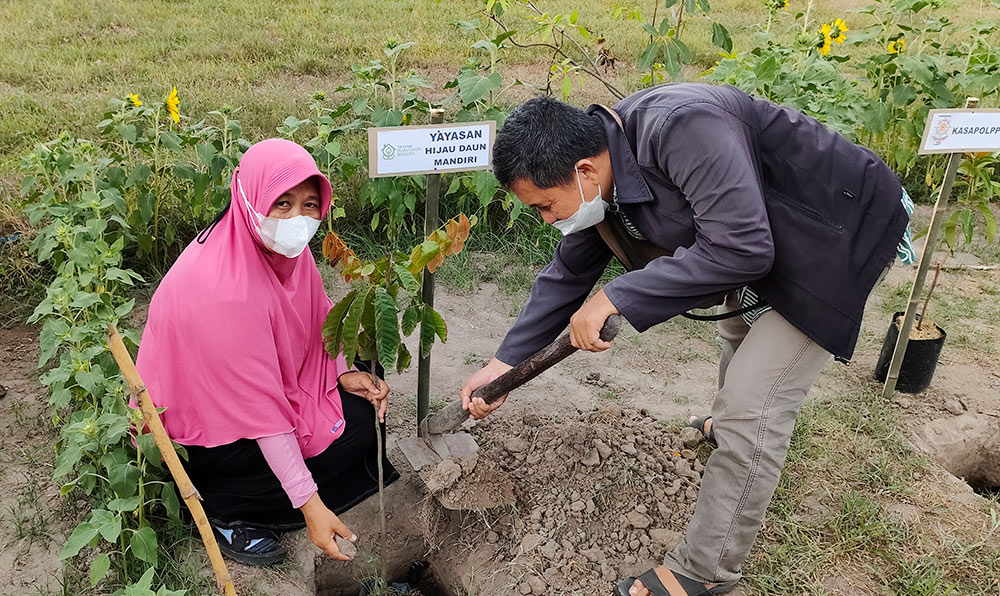Ketua Yayasan Hijau Daun Mandiri Kediri, Endang Pertiwi, dibantu salah satu relawan saat akan menanam pohon di area Sumber Banteng. foto: MUJI HARJITA/ BANGSAONLINE
