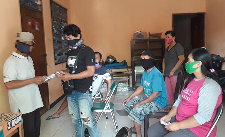 Warga RT 01 RW 03 Keluarahan Semampir, Kota Kediri saat antre menerima bantuan dari Relawan COvid-19. (foto: MUJI/ BANGSAONLINE)