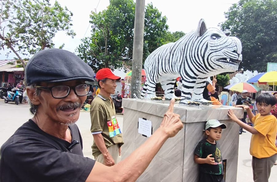 Mbah Suwari dan patung macan putih buatannya yang kini viral. Foto: Muji Harjita/BANGSAONLINE