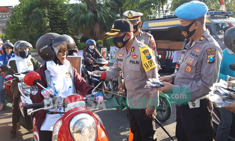 Kapolres Kediri Kota AKBP Miko Indrayana, saat memberikan masker kepada pengguna jalan. foto: MUJI HARJITA/ BANGSAONLINE