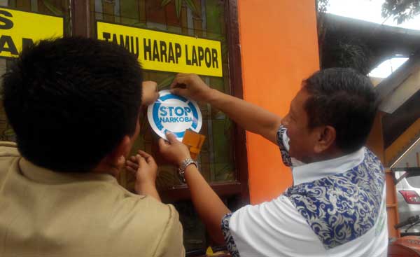 Petugas BNN Kota Mojokerto saat menyosialisasikan bahaya narkoba di instansi pemerintah dengan memasang stiker stop narkoba di DKP setempat. foto: yudi eko purnomo/ BANGSAONLINE