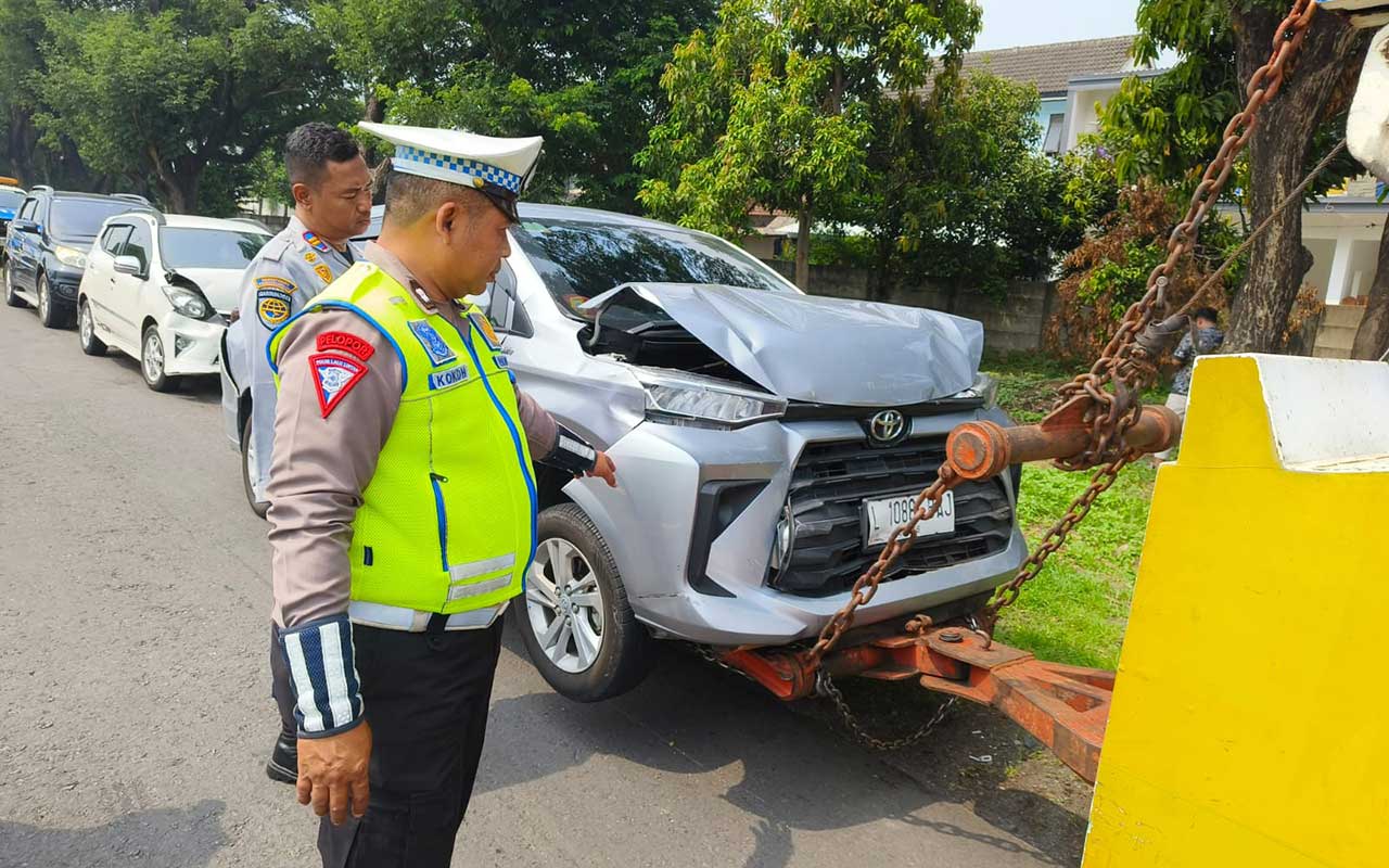 anggota kepolisian saat melakukan pengecekan terhadap salah satu mobil yang terlibat kecelakan beruntun di KM 748/B ruas Tol Sidoarjo arah Waru, Jumat (15/12/2023).