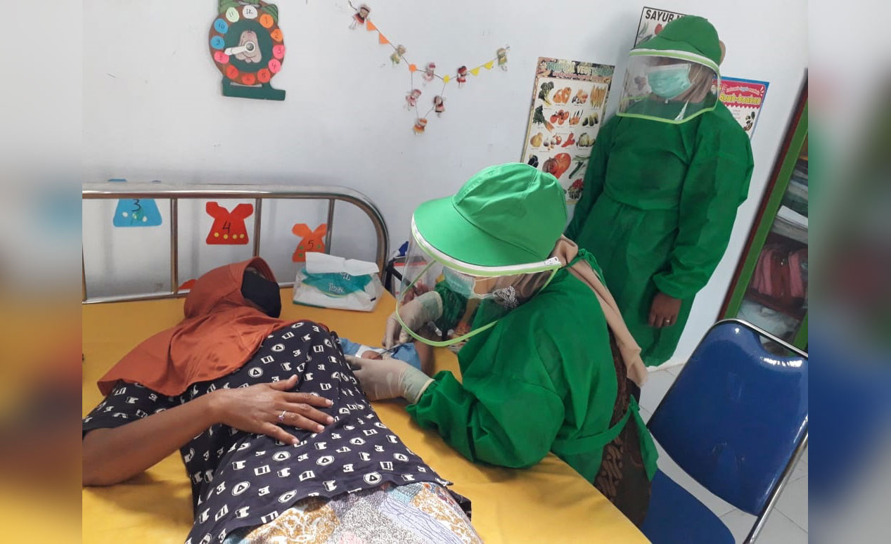 Salah satu akseptor KB saat dipasangi alat kontrasepsi menggunakan sistem suntik di Balai Desa Tengket, Arosbaya.