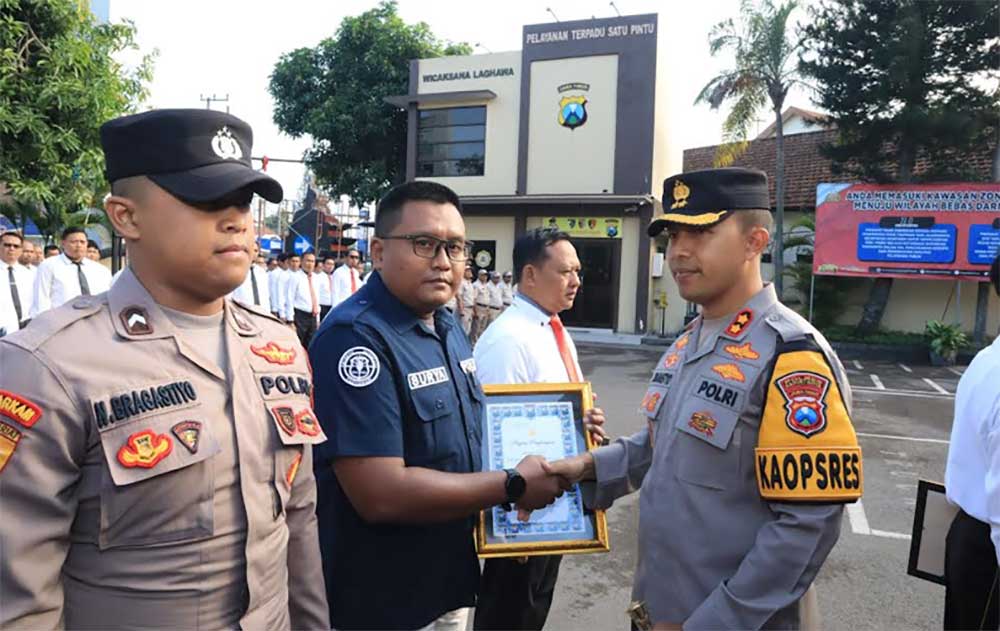 Kapolres Kediri Kota AKBP Bramastya Priaji saat menyerahkan penghargaan kepada Surya, anggota Tim Humas Polres Kediri Kota. Foto: Ist.