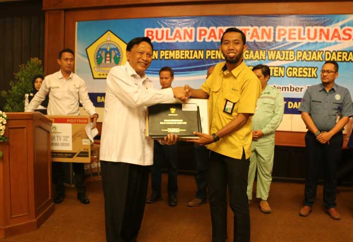 Bupati Sambari menyerahkan penghargaan kepada perwakilan PT. Petrokimia Gresik selaku penyumbang PBB terbesar.s