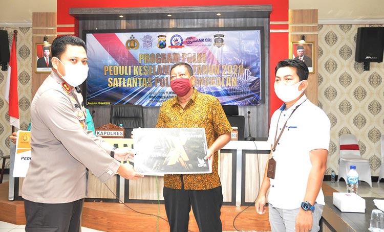 Kapolres Bangkalan AKBP Rama Samtama Putra menyerahkan kartu ATM secara simbolis kepada perwakilan sopir angkutan umum.