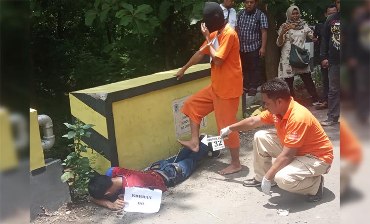 Pelaku saat memeragakan adegan menginjak korban. foto: SOFFAN/ BANGSAONLINE