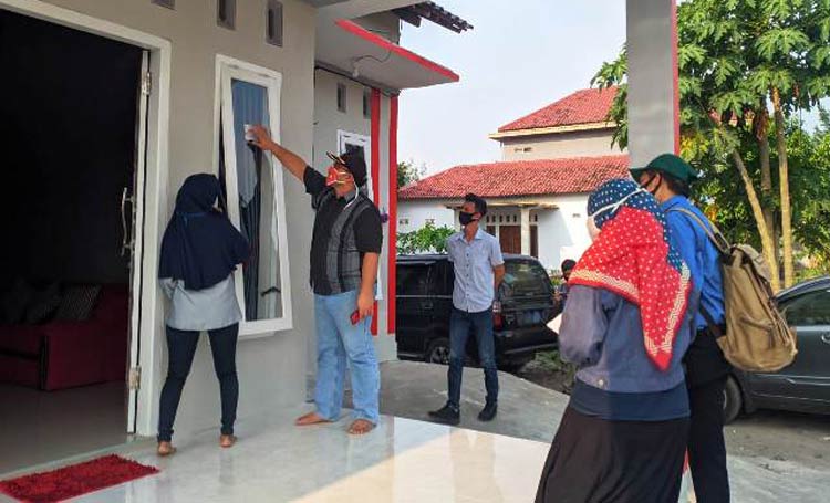 Eka Wisnu Wardana, Komisioner KPU Kabupaten Kediri Div. Perencanaan, Data, dan Informasi bersama PPDP saat menempelkan stiker di rumah warga yang sudah dicoklit. (foto: ist.)