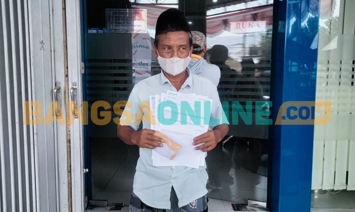 Ketua Kelompok penerima PKH saat menunjukkan print out di BRI Cabang Sampang. foto: MUTAMMIM/BANGSAONLINE