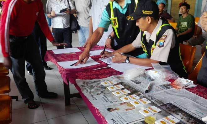 Petugas saat menerima sample urine dari para sopir untuk dites narkoba. foto: EKY NURHADI/ BANGSAONLINE