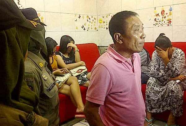 Petugas saat mengamankan wisma terselubung di kawasan lokalisasi Dolly. Dari penggerebekan ini, petugas mengamankan 3 mucikari dan 1 germo. (foto: rusmiyanto/BANGSAONLINE)