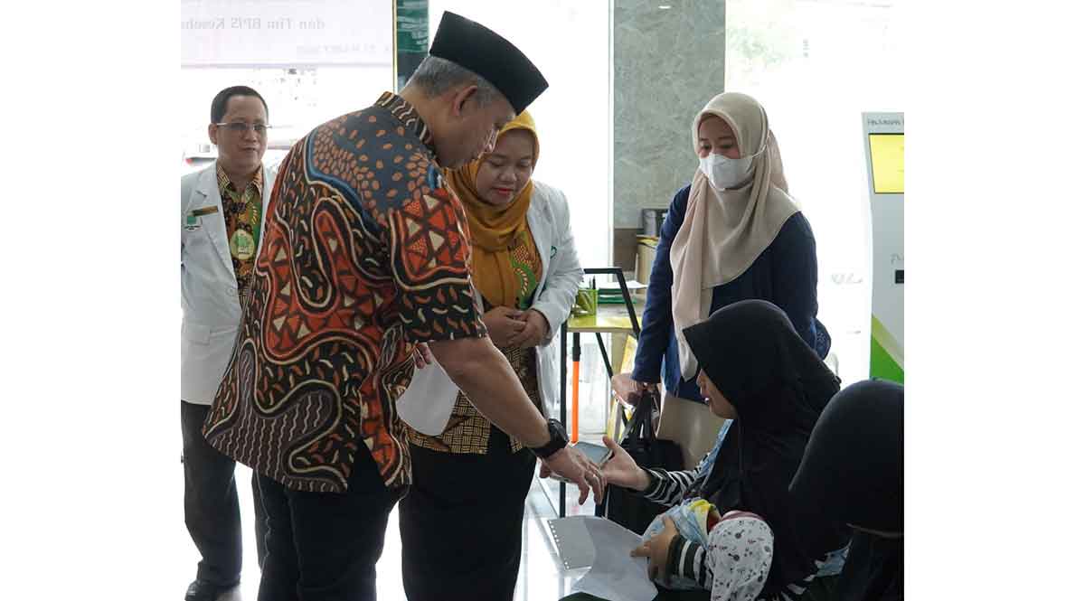Peserta JKN di Gresik saat menunjukkan tampilan antrean online Mobile JKN di ponselnya.