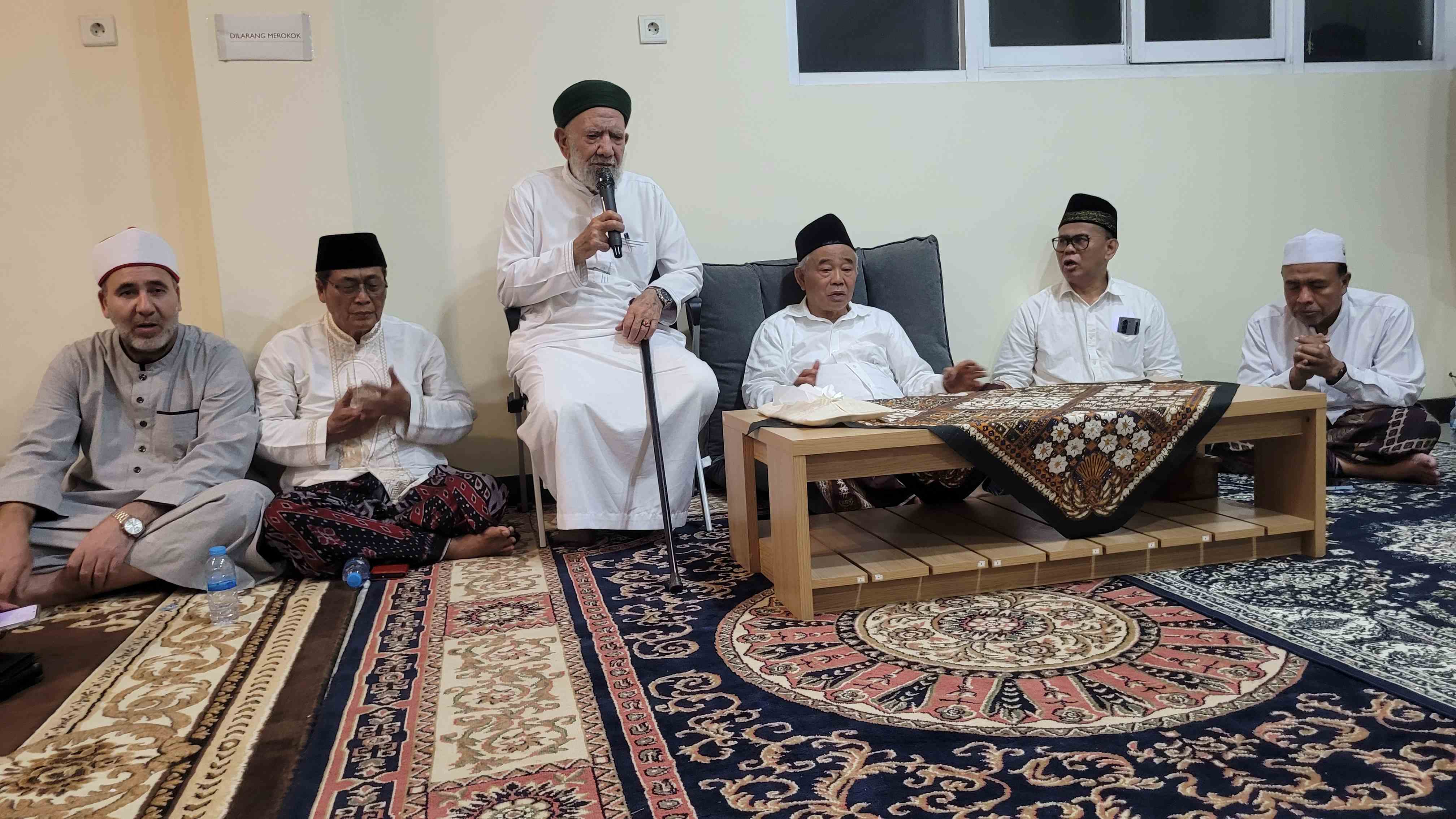Syaikh Abdul Aziz Asy-Syahawi (duduk di kursi) dan Prof Dr KH Asep Saifuddin Chalim, MA, serta para kiai dan tokoh dalam acara shalat malam dan istighatsah juga tahlil di kediaman Ning Imah di kawasan Pondok Pesantren Amanatul Ummah Jalan Siwalankerto Utara Surabaya, Jumat (17/10/2025) malam. Foto: bangsaonline