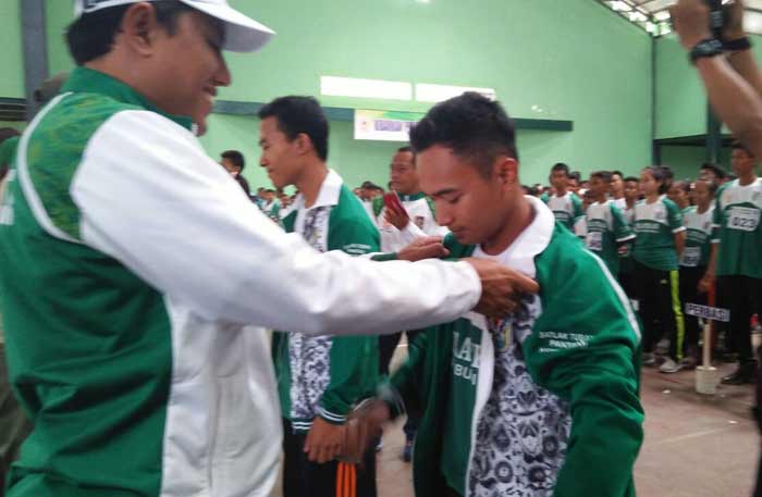 Mirza, Ketua KONI Tuban saat mengenakan jaket kepada atlet.
