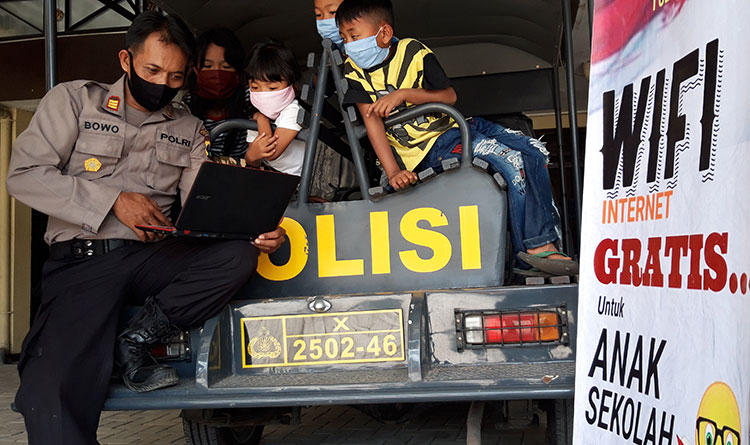 Kapolsek Puncu, AKP Bowo Wicaksono saat membimbing anak-anak menggunakan internet di Mapolsek Puncu. (foto: MUJI/ BANGSAONLINE)