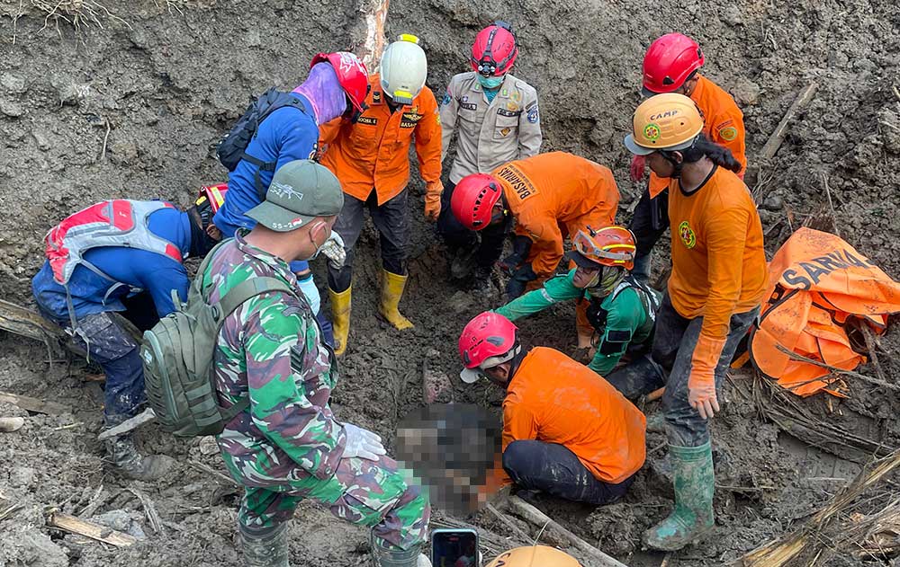 Petugas BPBD Jatim saat mengevakuasi salah satu korban longsor di Trenggalek.