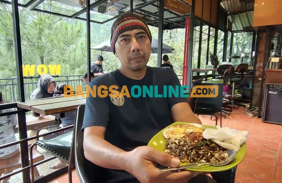 Adi Hasto saat menunjukkan sego tiwul, kuliner khas Kabupaten Kediri. Foto: MUJI HARJITA/BANGSAONLINE