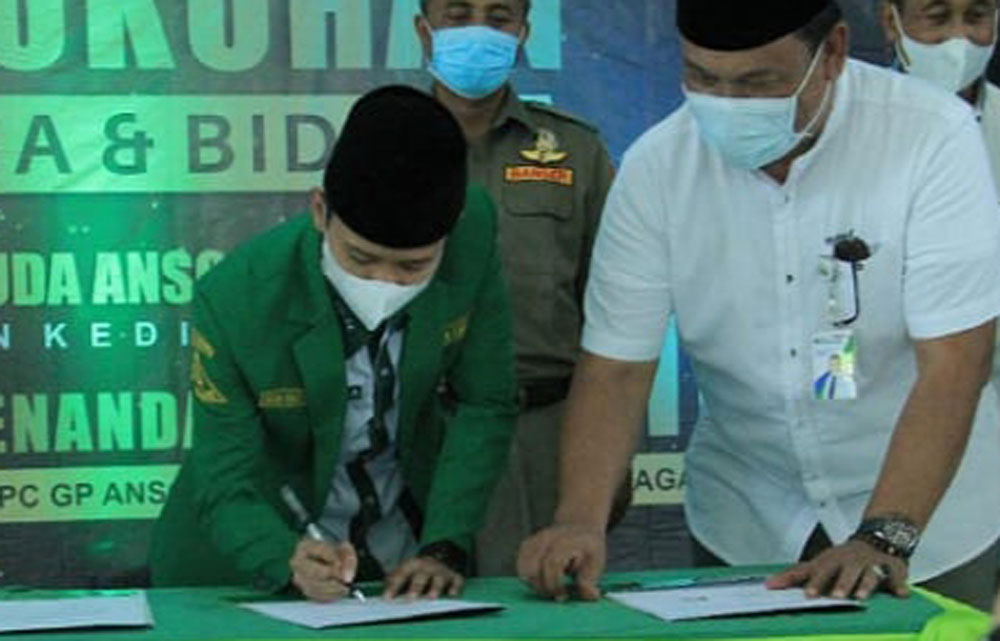 Ketua PC GP Ansor Kabupaten Kediri, Rizmi Haitami Azizi saat menandatangani kerja sama dengan BPJS Ketenagakerjaan.  foto: ist.
