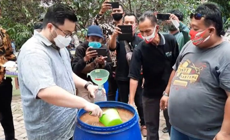 Hanindhito Himawan Pramono alias Dhito, Calon Bupati Kediri 2020 saat "memanen" pupuk cair organik dengan memasukannya ke botol plastik, yang selanjutnya diberikan secara simbolis kepada wakil petani. foto: MUJI HARJITA/ BANGSAONLINE