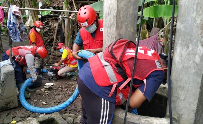 Tim Wash PMI Jember sedang melakukan pembersihan sumur warga.